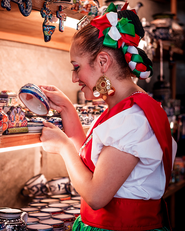Tienda de souvenir Mexicano y mujer con vestimenta tradicional Mexicana.